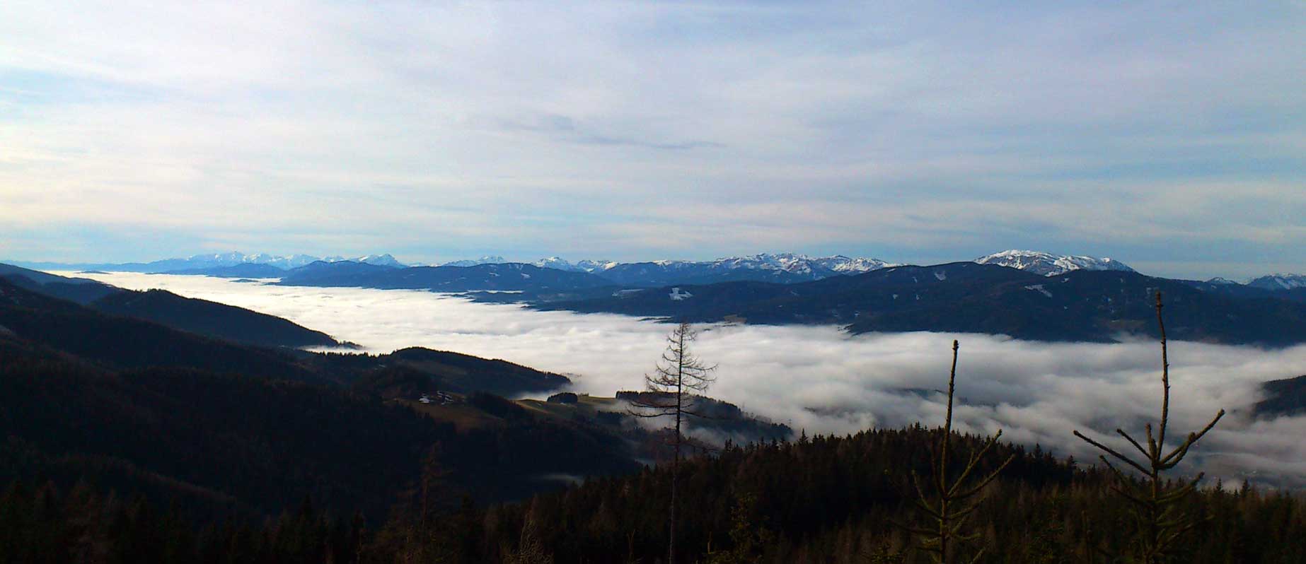Freizeit rund um das Berggasthaus Friedrichhütte am Stuhleck - Foto zeigt Panoramaaufnahme mit dem vernebelten Mürztal und den Alpengipfeln von z.B. Hochschwab, Veitsch und Rax im Hintergrund
